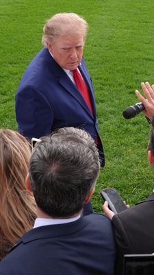 US-Präsident Donald Trump (hinten) spricht auf dem Südrasen des Weißen Hauses mit Reportern.