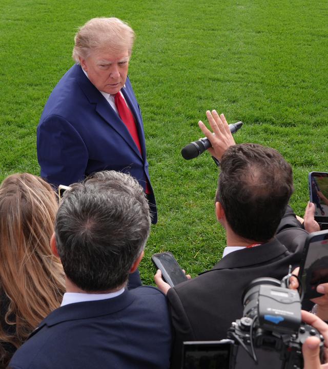 US-Präsident Donald Trump (hinten) spricht auf dem Südrasen des Weißen Hauses mit Reportern.