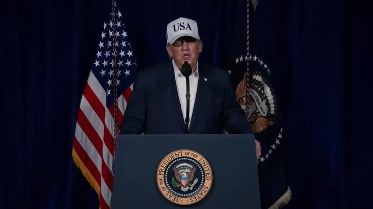 Donald Trump gibt vor einem Pult eine Presseerklärung.