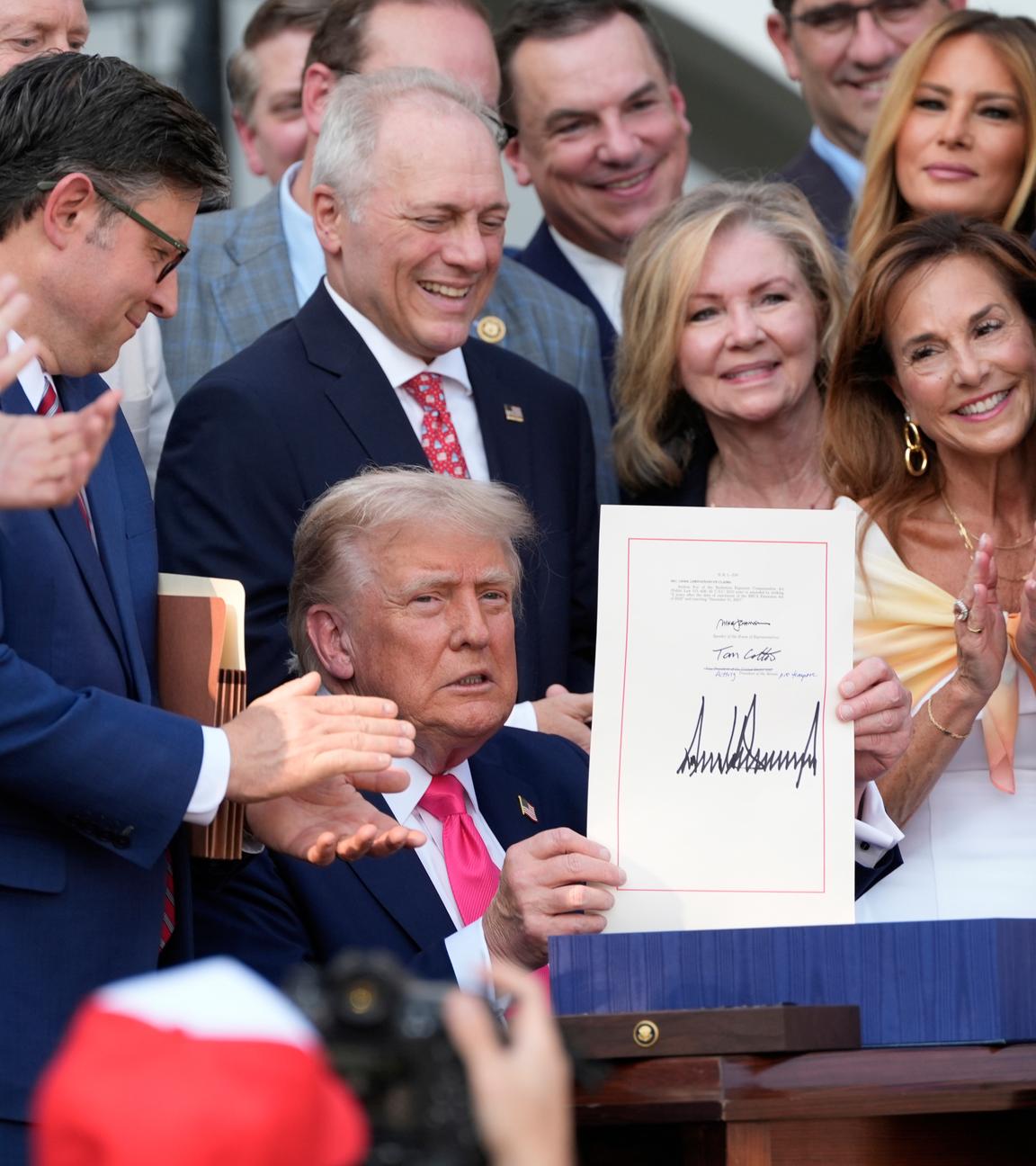 Trump hält das frisch unterzeichnete Steuergesetz hoch.