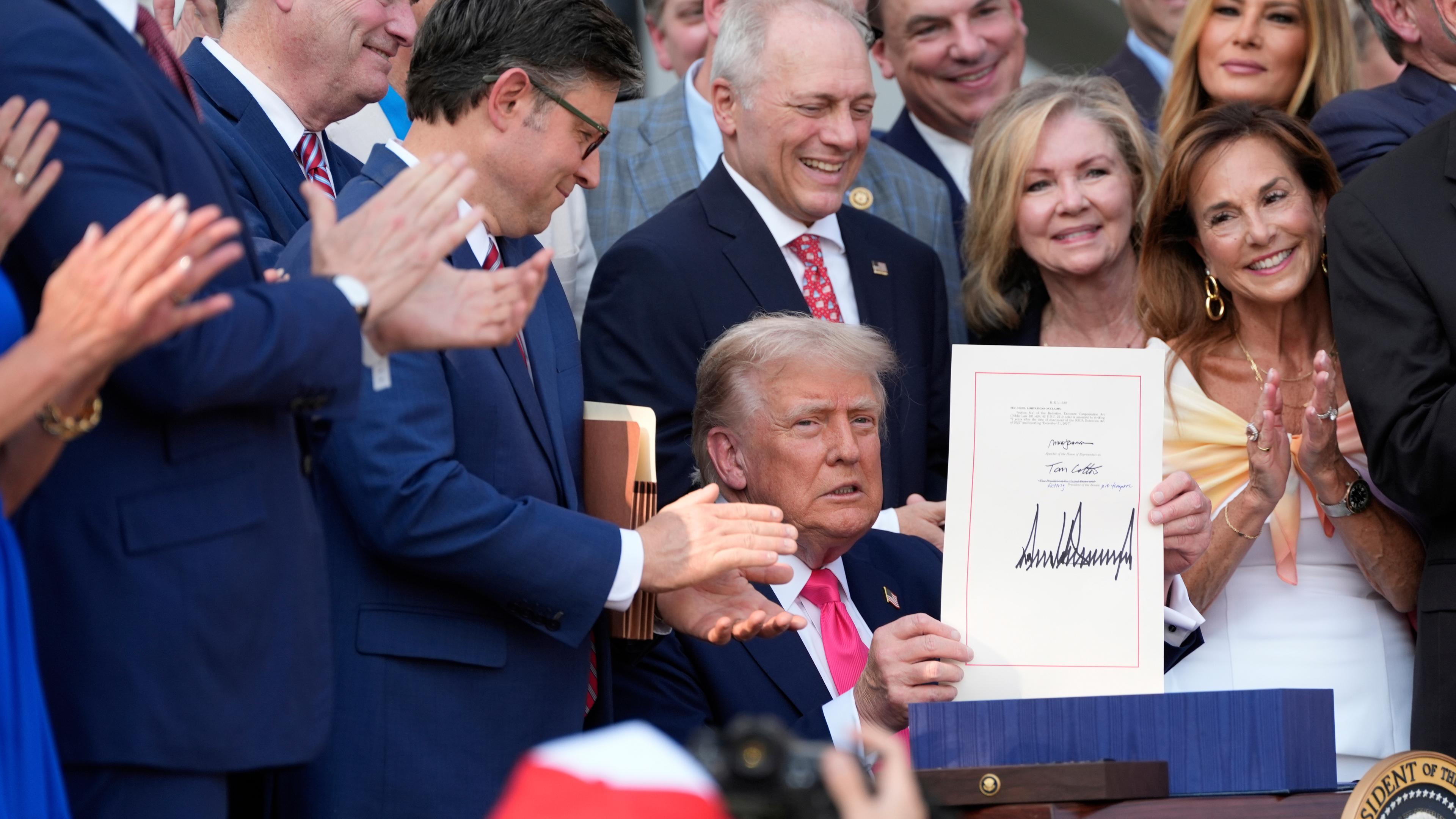 Trump hält das frisch unterzeichnete Steuergesetz hoch.
