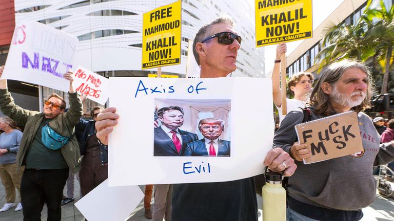 Menschen versammeln sich vor dem Tesla-Showroom in Santa Monica, um gegen Elon Musks übergroßen Einfluss in der neuen Trump-Regierung zu protestieren.