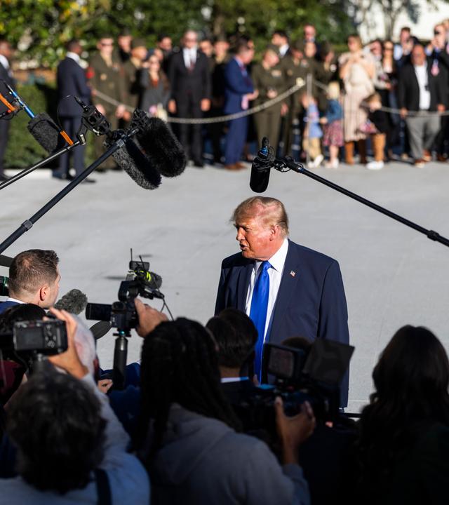 S-Präsident Donald Trump (Mitte) spricht mit Reportern, als er das Weiße Haus verlässt, um zu einer Wahlkampfveranstaltung in Iowa zu reisen, in Washington, DC, USA, am 22. Oktober 2026.