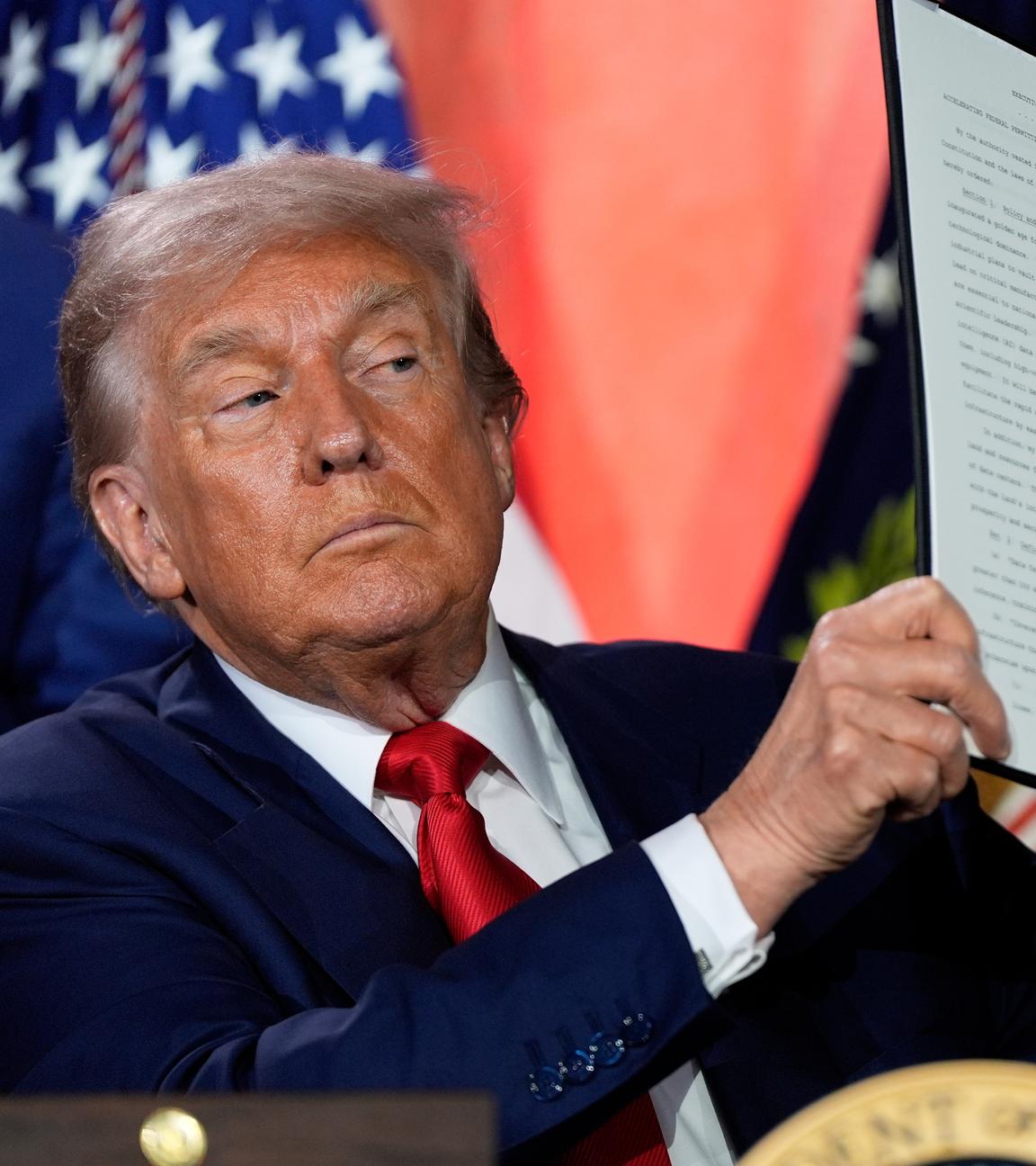 US-Prasident Trump präsentiert seinen unterschriebenen Aktionsplan. Er guckt ernst.