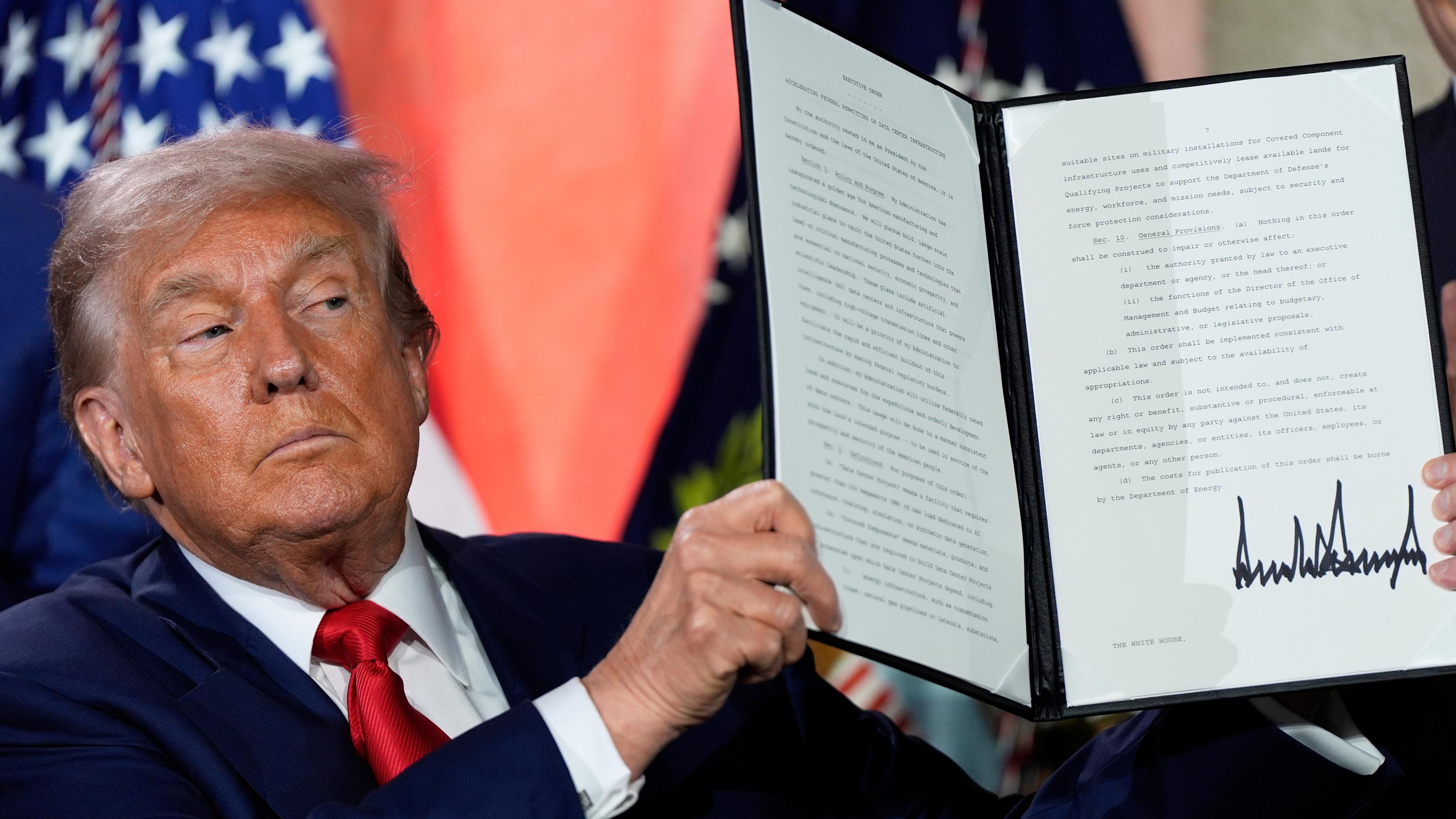 US-Prasident Trump präsentiert seinen unterschriebenen Aktionsplan. Er guckt ernst.