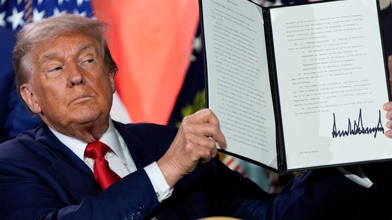 US-Prasident Trump präsentiert seinen unterschriebenen Aktionsplan. Er guckt ernst.