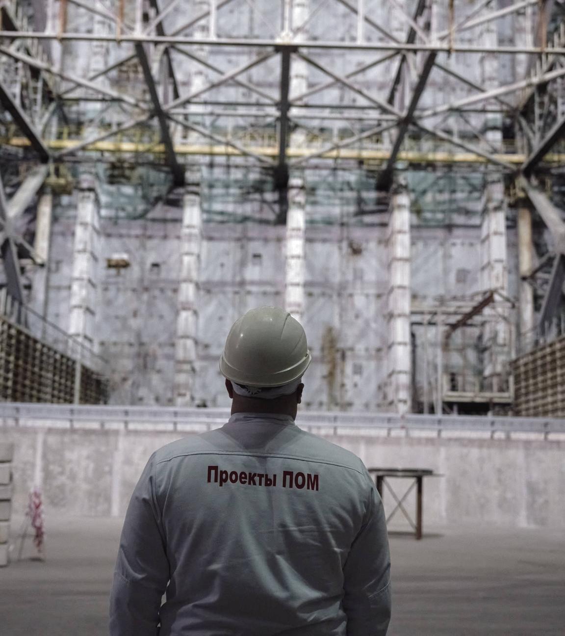 Ein Überwachungsspezialist blickt auf das Schutzbauwerk über dem zerstörten Reaktor 4 in Tschernobyl.