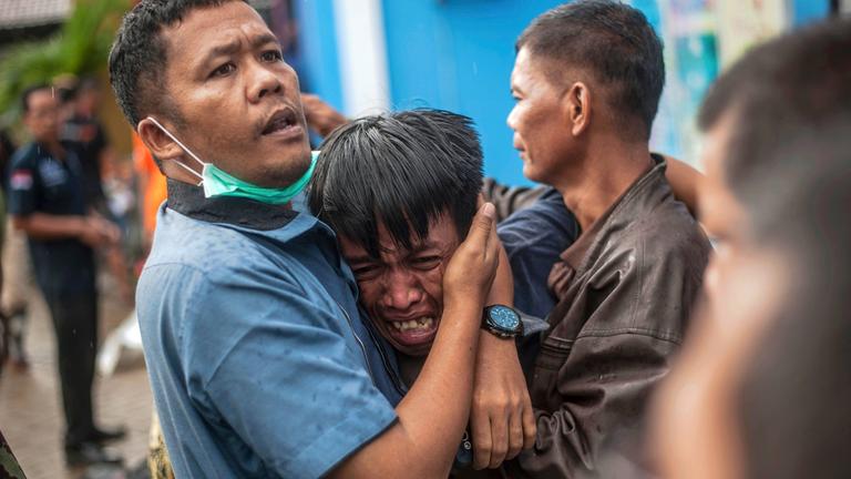 Männer trauern nach dem Tsunami in Carita (Indonesien), aufgenommen am 24.12.2018