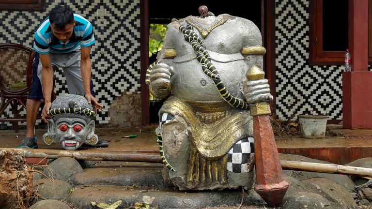 Ein Arbeiter hebt einen Kopf einer zerstörten Statue in Pandeglang (Indonesien), aufgenommen am 24.12.2018