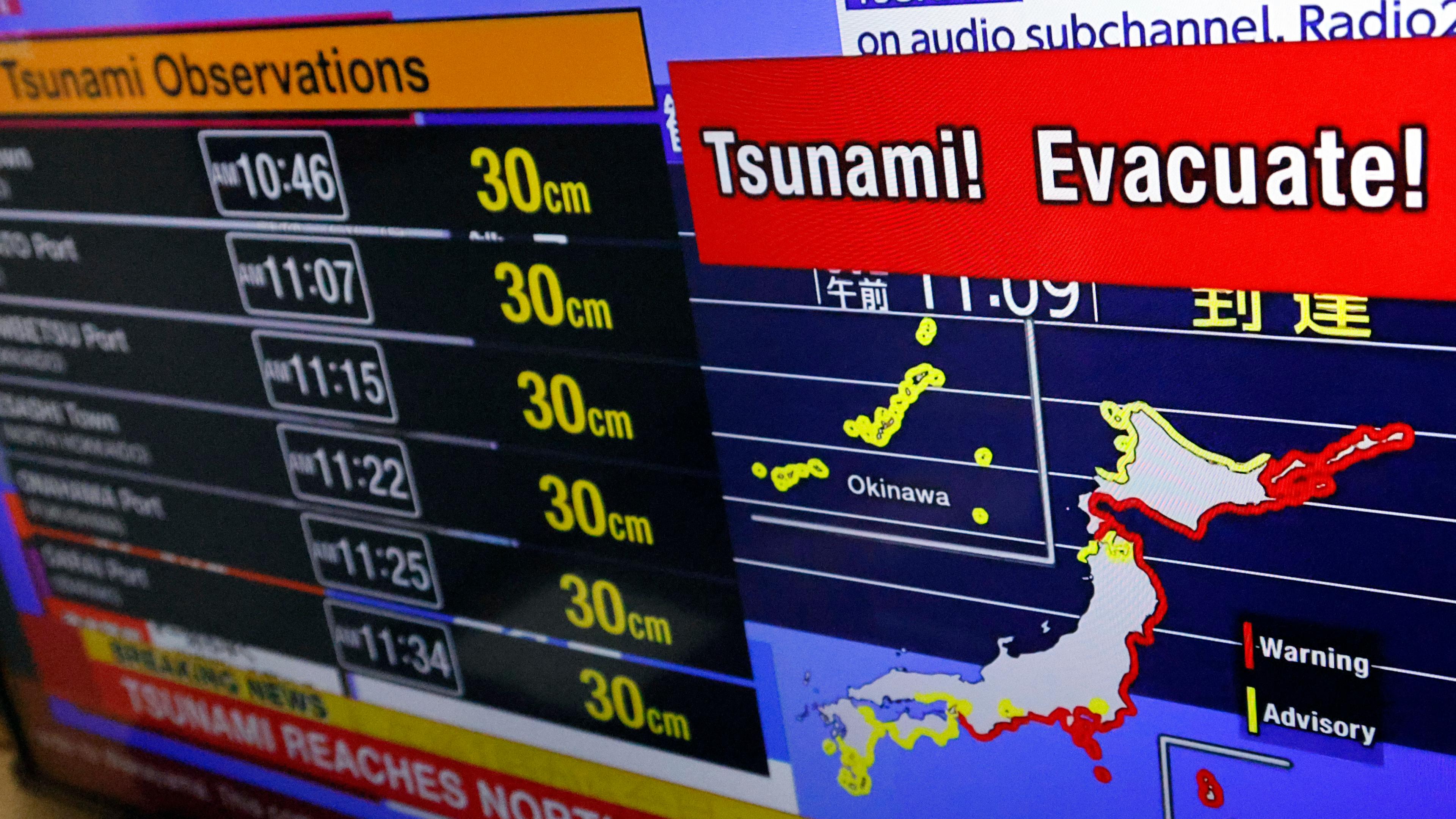 Ein Fernsehbildschirm zeigt eine Karte von Japan mit Tsunami Warnungen.