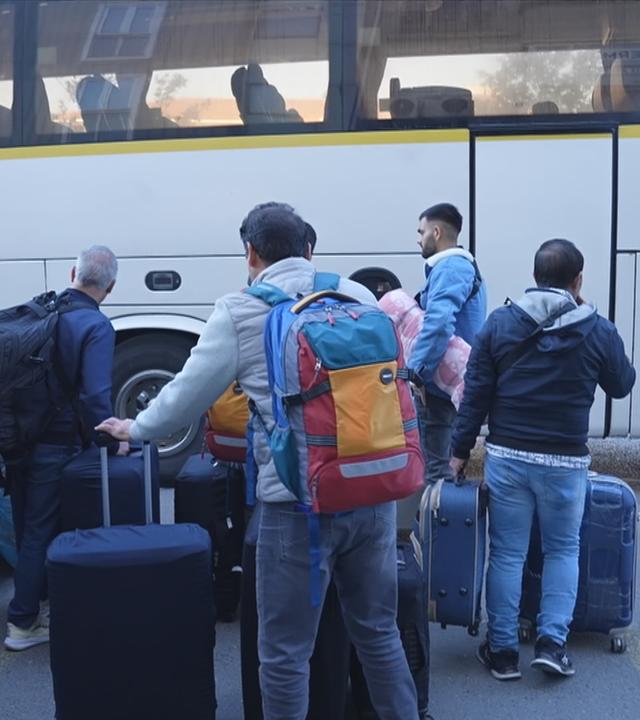 Reisende vor einem Bis