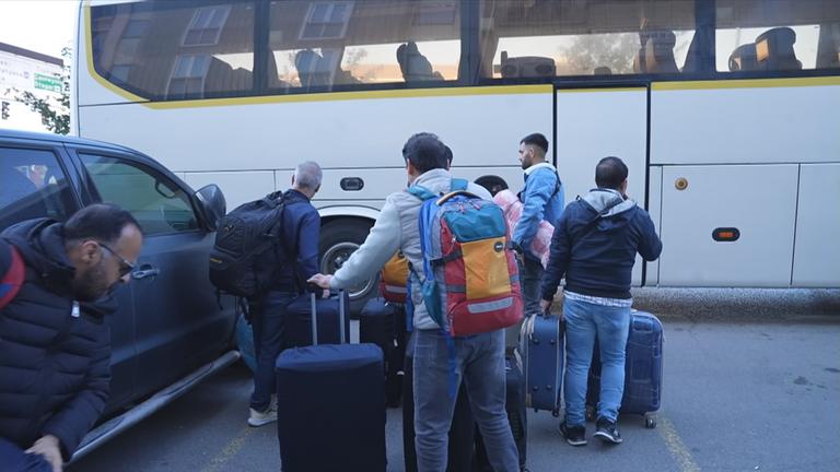 Reisende vor einem Bis