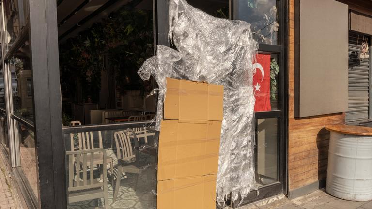 An einem türkischen Stand für Streetfood, der von den türkischen Behörden geschlossen wurde, hängen eine Pappe und eine Plastikplane neben einer türkischen Fahne. 