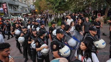 Mehrere Sicherheitskräfte stehen inmitten einer Demonstration gegen die Anti-LGBTQ-Razzien in der Türkei.