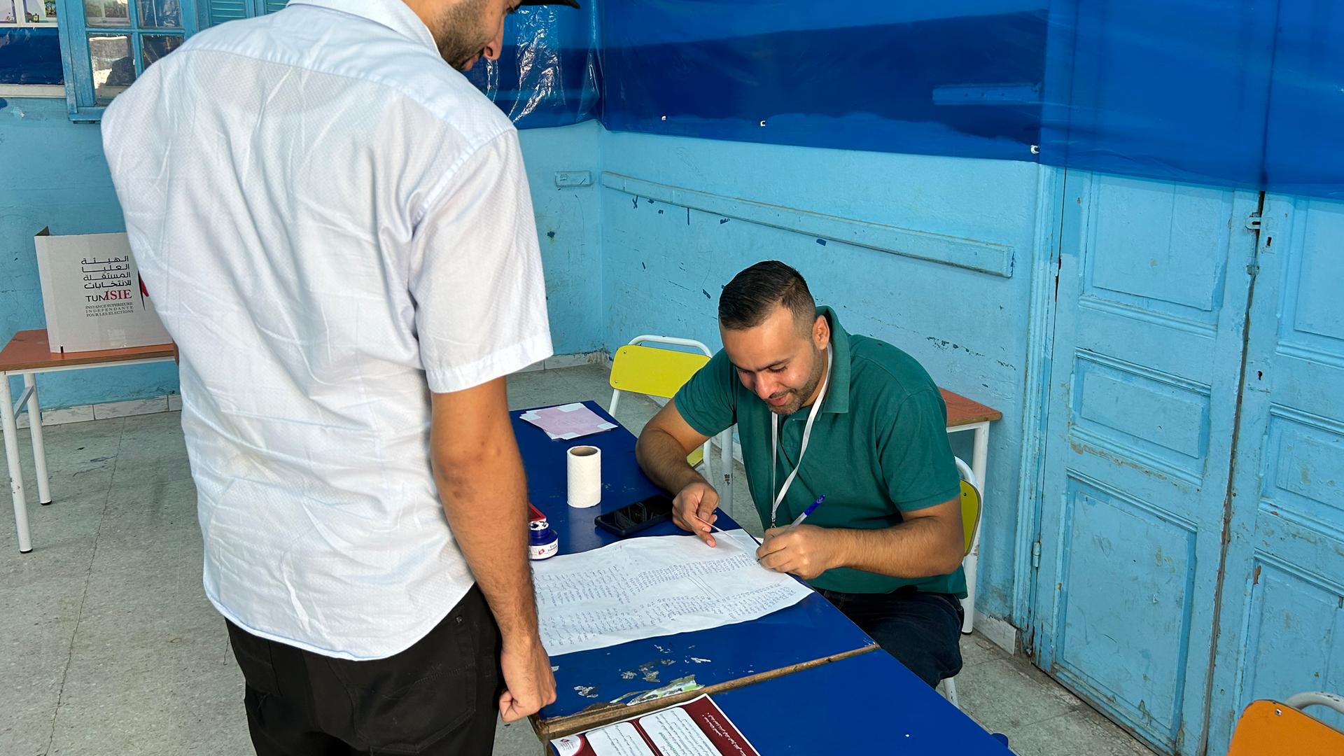 Bei der Wahl in Tunesien wird der Namen eines Mannes auf Stimmberechtigungs-Listen überprüft