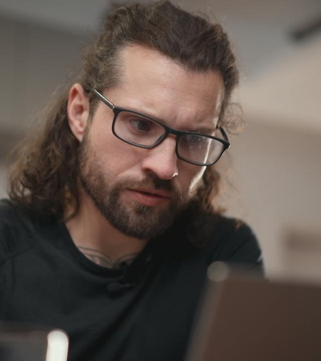 Ein Mann schaut auf seinen Laptop.