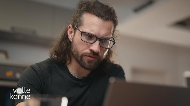 Ein Mann schaut auf seinen Laptop.