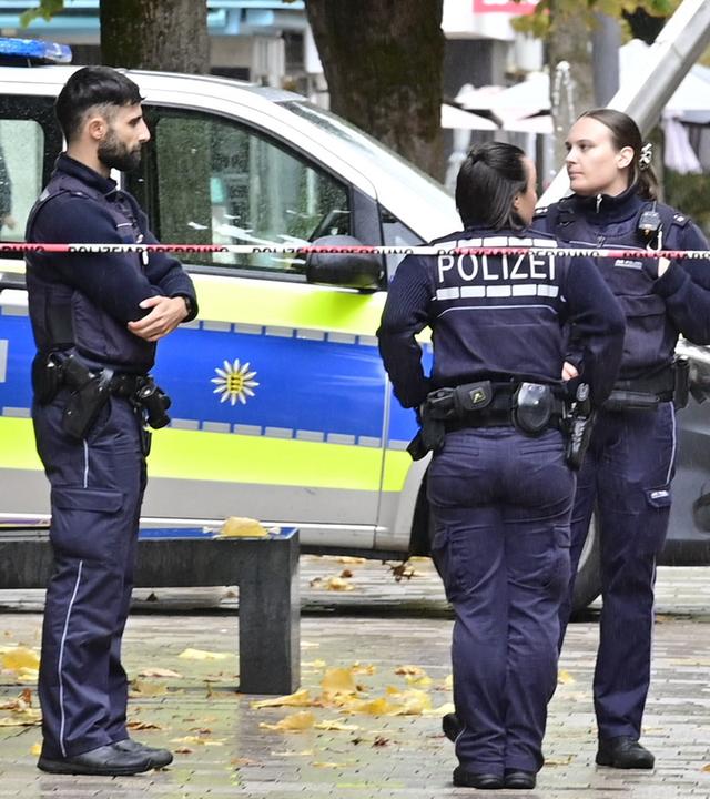 Einsatzkräfte der Polizei stehen an einem abgesperrten Bereich zu einem Schusswechsel in einer Fußgängerzone nahe dem Rathaus.