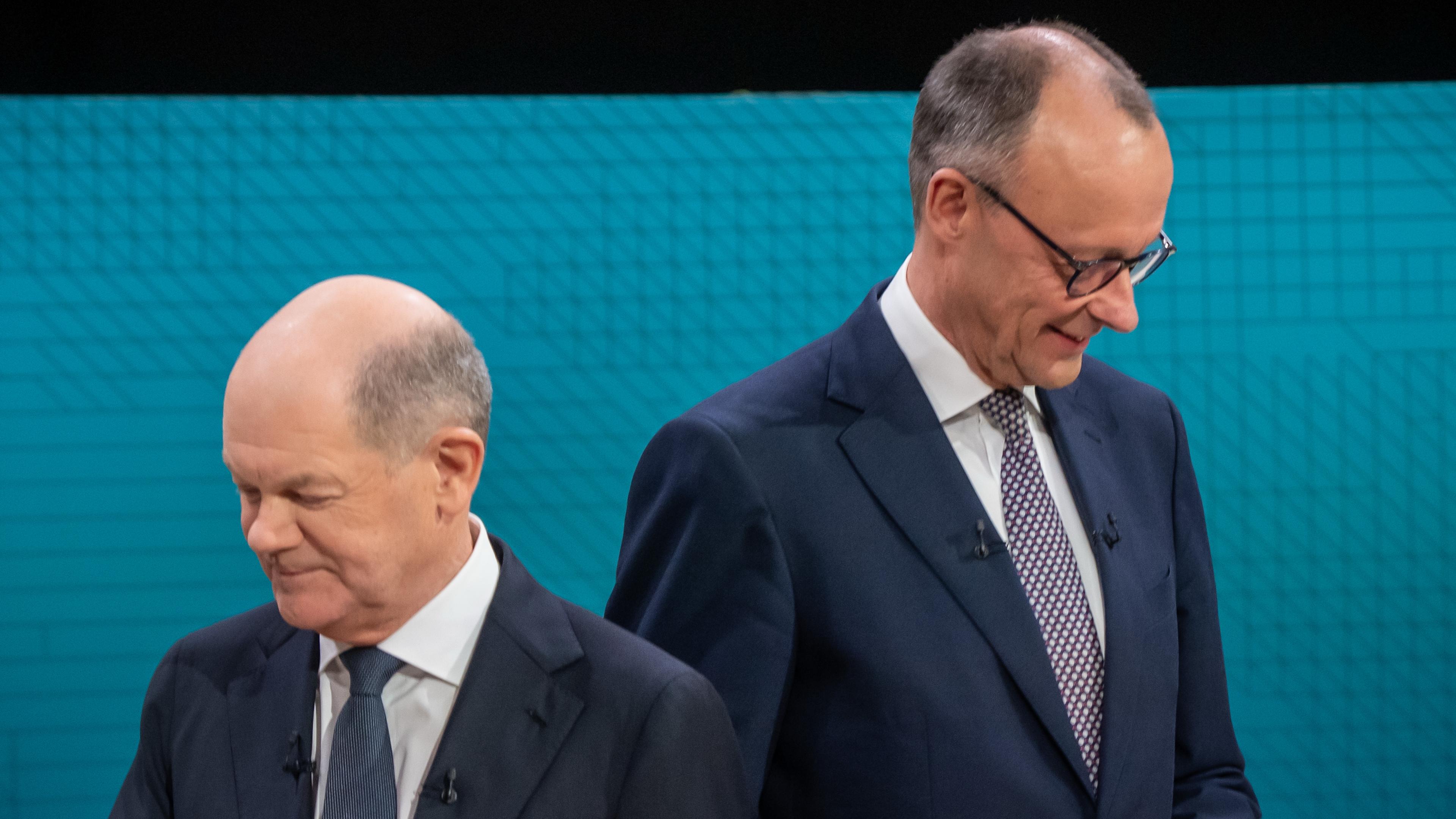 Olaf Scholz und Friedrich Merz wenden sich beim TV-Duell voneinander ab.