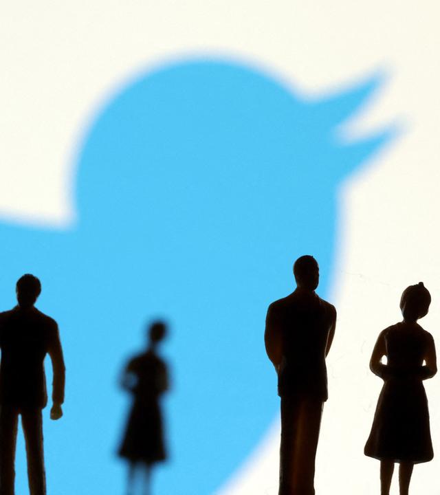 Vor dem Twitterlogo stehen schattige Figuren