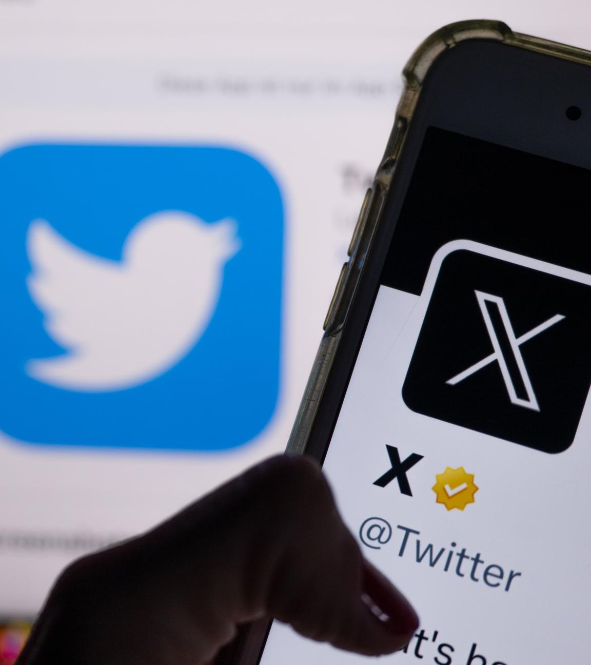 Auf dem Profil von Twitter auf dem Smartphonebildschirm ist der weiße Buchstabe X auf schwarzem Hintergrund zu sehen, während im Hintergrund das bisherige Logo von Twitter angezeigt wird.