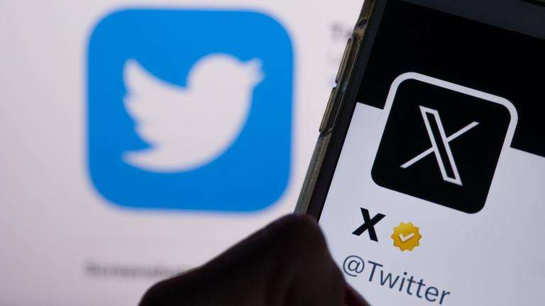 Auf dem Profil von Twitter auf dem Smartphonebildschirm ist der weiße Buchstabe X auf schwarzem Hintergrund zu sehen, während im Hintergrund das bisherige Logo von Twitter angezeigt wird.