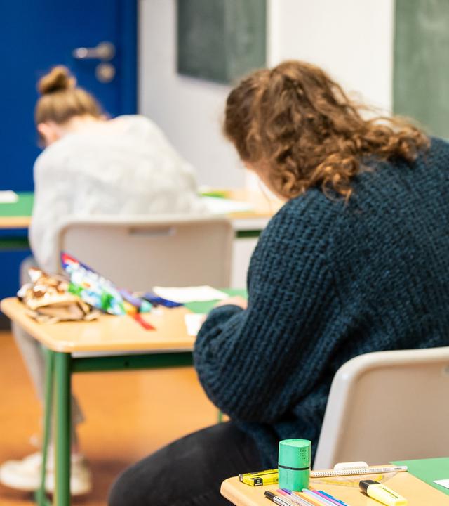 Schülerinnen und Schüler sitzen während der schriftlichen Abiturprüfung in Biologie in einem Klassenzimmer. (Archiv)