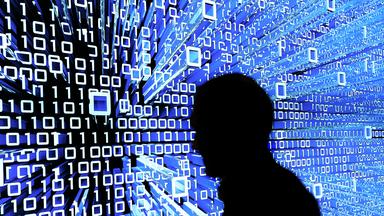 Ein Messebesucher geht an einem Leuchtdisplay auf der CeBIT vorbei. (Archiv)