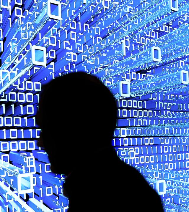 Ein Messebesucher geht an einem Leuchtdisplay auf der CeBIT vorbei. (Archiv)