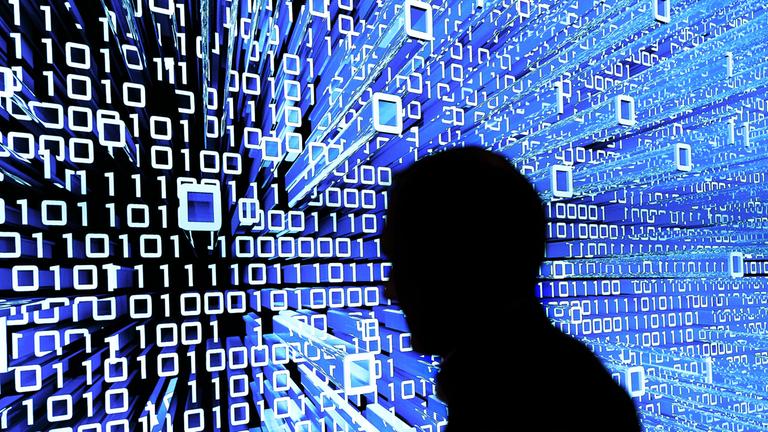 Ein Messebesucher geht an einem Leuchtdisplay auf der CeBIT vorbei. (Archiv)