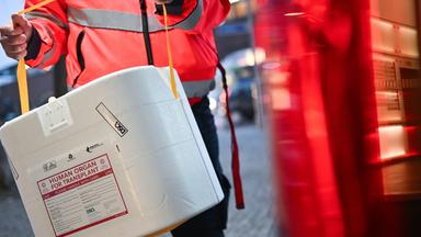  Ein Mitarbeiter der Malteser stellt eine Kühlbox für eine Organspende in einen Transporter. (Gestellte Szene)