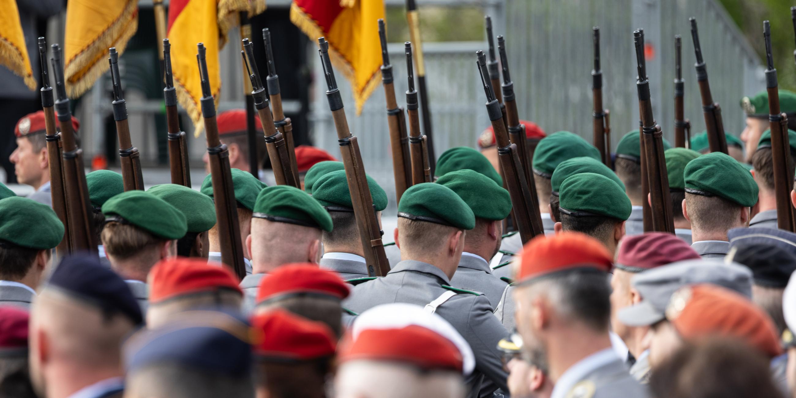 Soldaten der Bundeswehr laufen mit geschulterter Waffe während einer Veranstaltung.