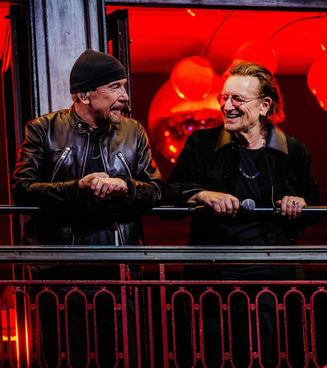 Auf dem Bild ist der Auftritt von U2 auf dem Balkon des Bewley’s Cafés in Dublins Grafton Street zu sehen. Die Band feierte dort ihr 50-jähriges Jubiläum mit einem kostenlosen Konzert vor Tausenden Fans.