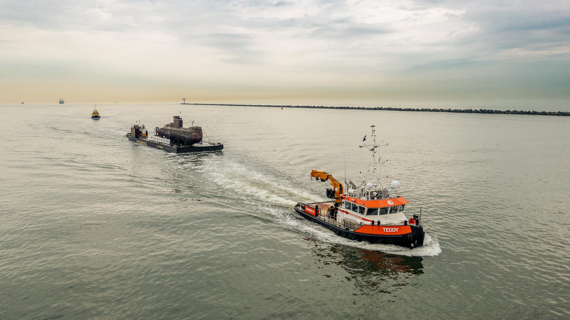 Ein U-Boot auf einem wird von einem Ponton Schlepper gezogen.