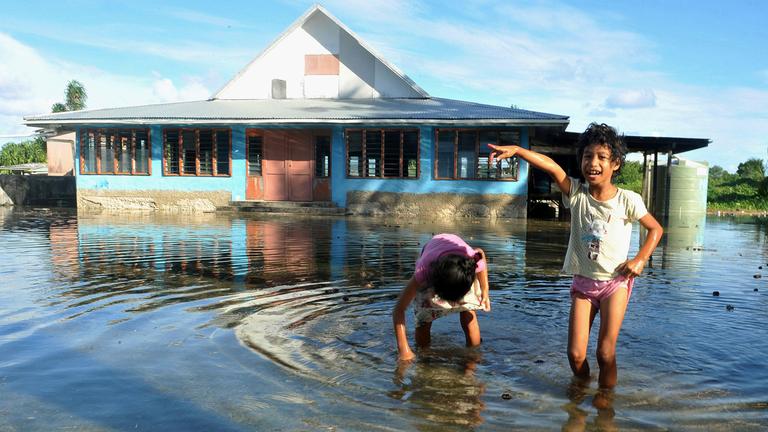 Kinder spielen am 30.01.2014 auf einem vom Meerwasser überflutetem Platz in Funafuti, der Hauptstadt von Tuvalu