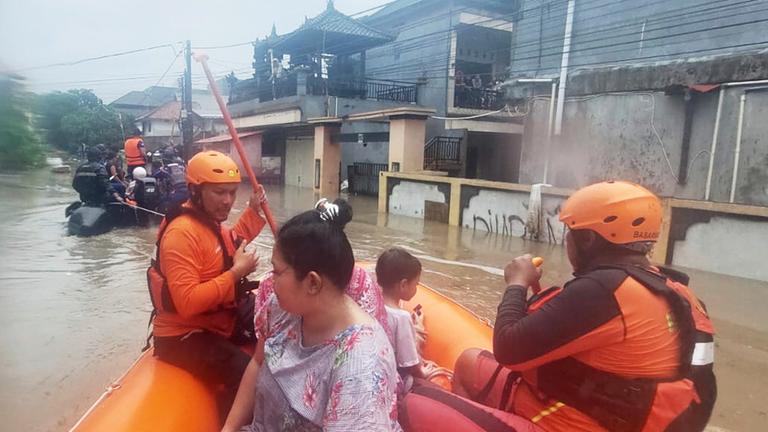 Auf diesem von der Nationalen Such- und Rettungsbehörde Indonesiens (BASARNAS) via AP veröffentlichten Foto evakuieren Retter in einem Schlauchboot Bewohner aus ihrem überfluteten Haus in Denpasar, Bali. 
