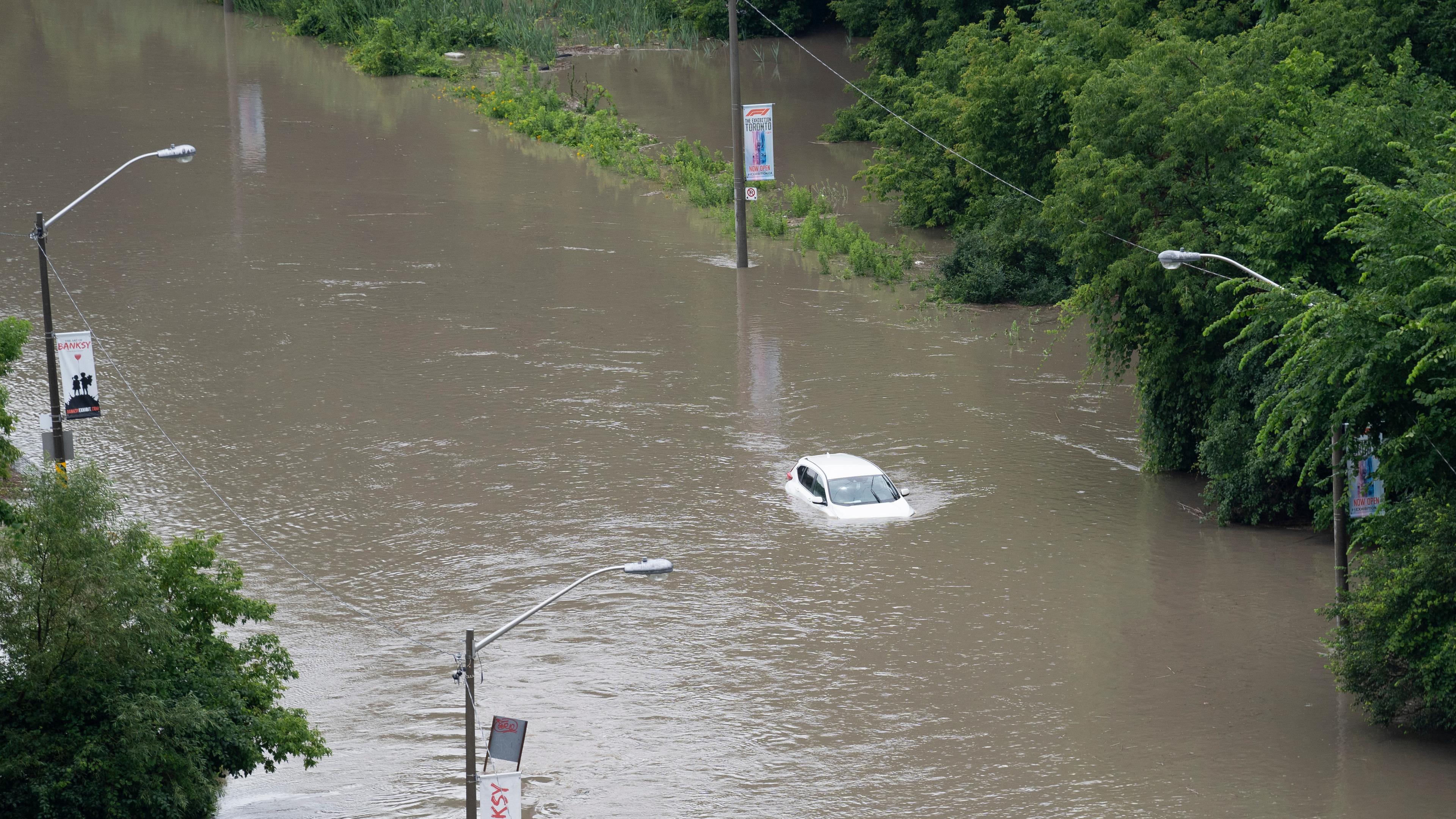 Nach heftigen Regenfällen in Toronto ist am Dienstag, dem 16. Juli 2024, ein Auto teilweise im Hochwasser im Don Valley untergetaucht.