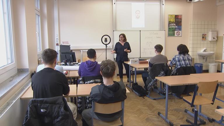 Übergangslotsin spircht vor Schulklasse.