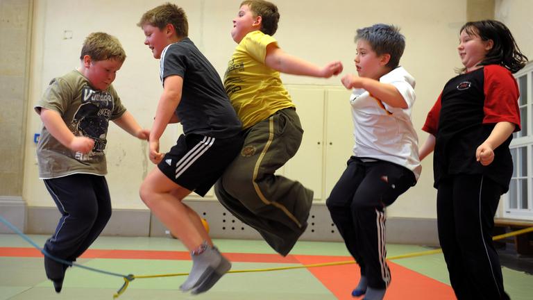 In einer Sporthalle in Leipzig trainieren übergewichtige Kinder Seilspringen.
