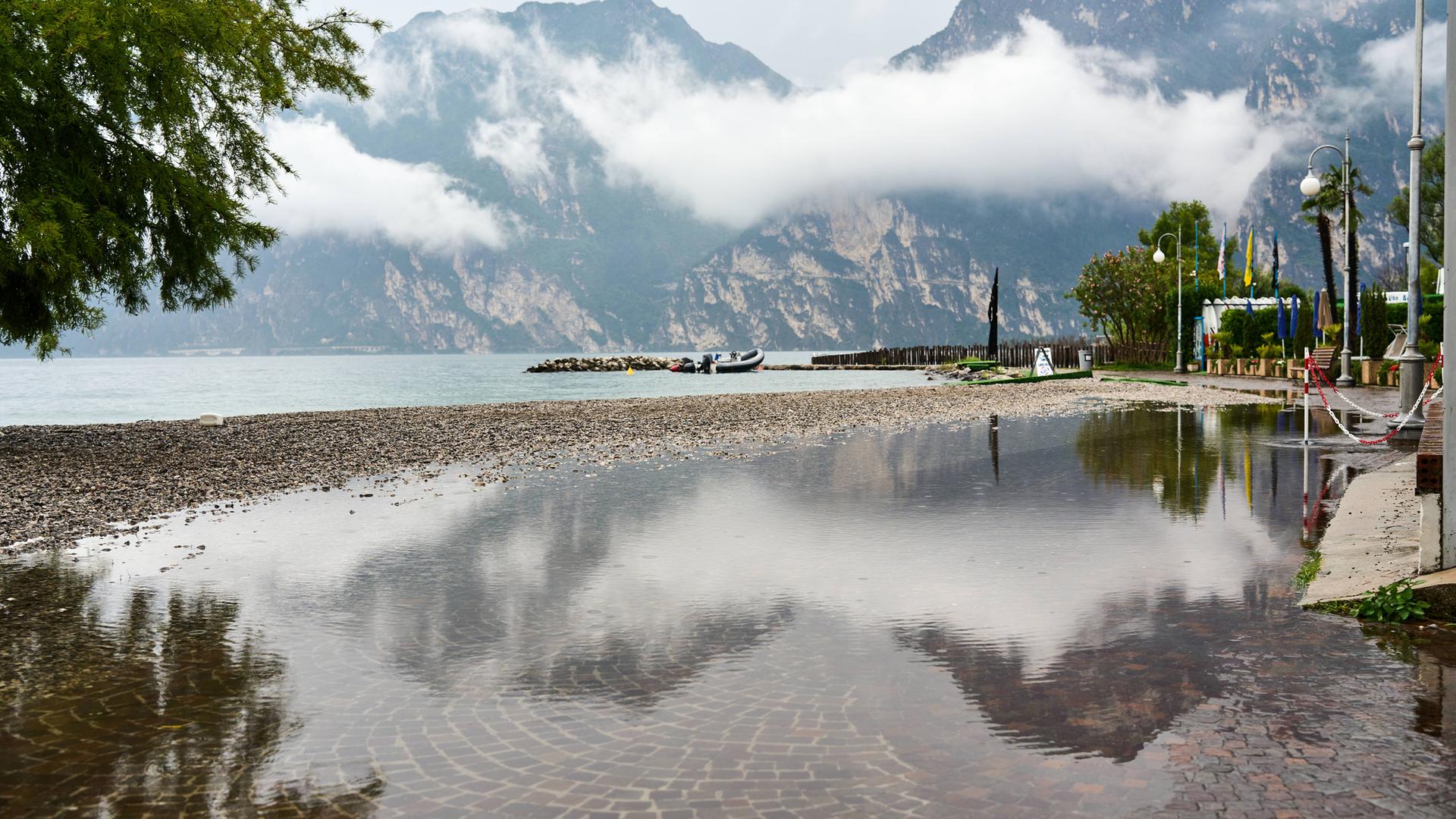 Nago Torbole, Gardasee, Italien – 25. Juni 2024: Themenbild Sturm am Gardasee: Der Regen hat stellenweise zu Überschwemmungen geführt. Ein Weg am See steht unter Wasser 