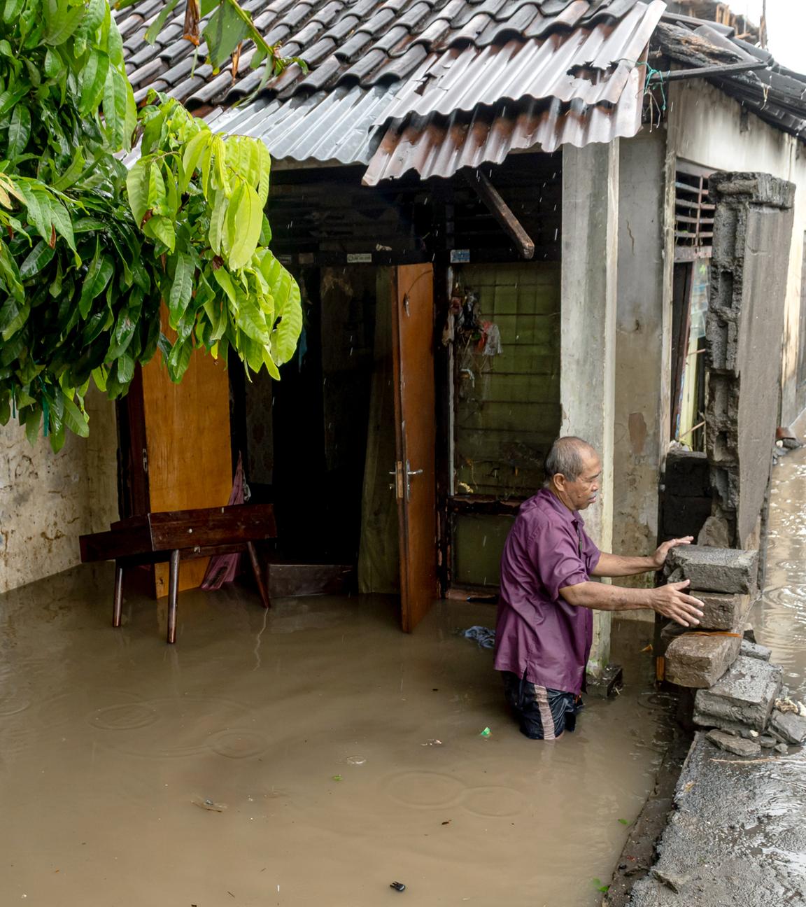 Ein Mann steht in der Nähe seines überschwemmten Hauses, nachdem Denpasar, Bali, von starken Regenfällen heimgesucht wurde. 