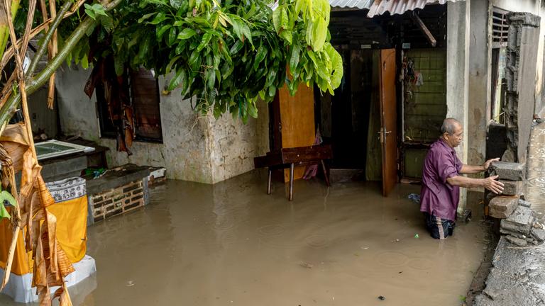 Ein Mann steht in der Nähe seines überschwemmten Hauses, nachdem Denpasar, Bali, von starken Regenfällen heimgesucht wurde. 