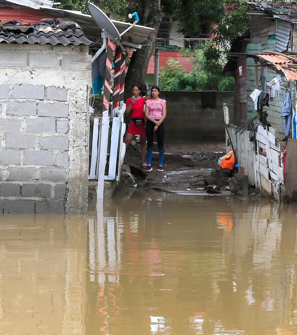 Menschen stehen nahe Überschwemmungswasser im Stadtteil Zarabanda in Montería, Kolumbien, am 6. Februar 2026.