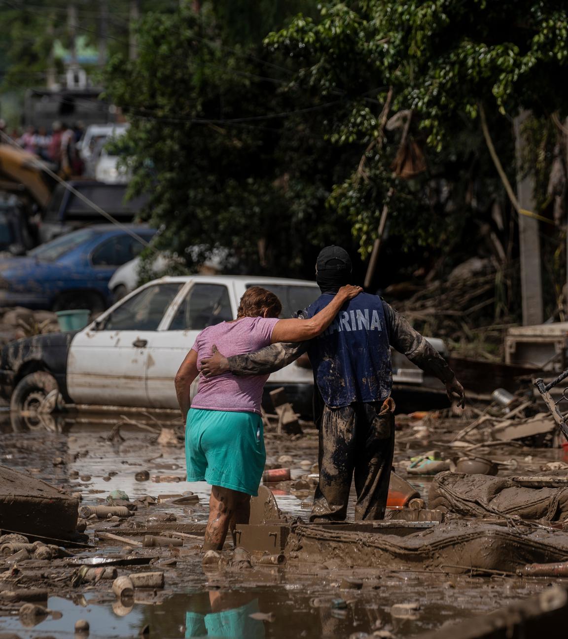 Ein Marine hilft einer Frau am Sonntag, dem 12.10.2025, in Poza Rica im mexikanischen Bundesstaat Veracruz, eine überflutete Straße zu überqueren. 