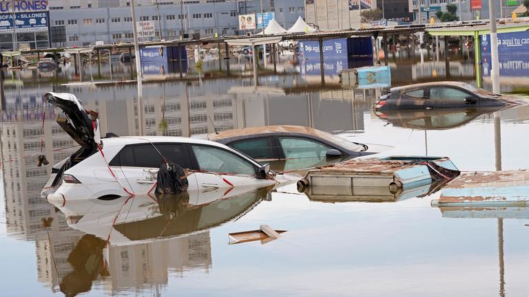 Autos stehen nach Überschwemmungen in Valencia halb unter Wasser