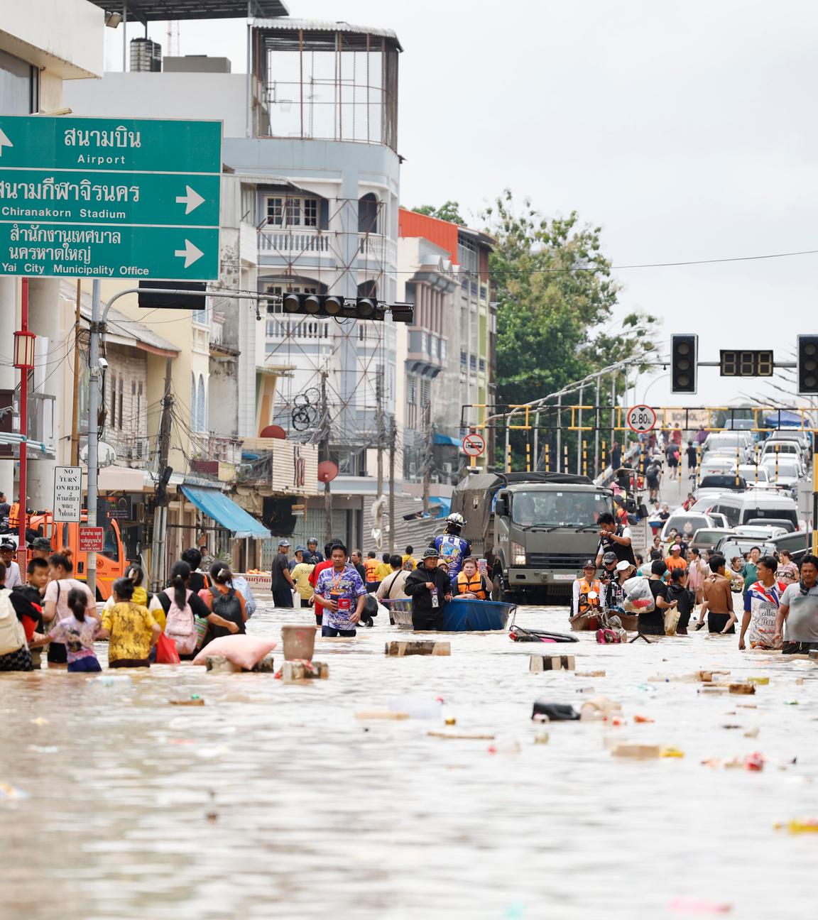 Thailand, Songkhla: Menschen waten durch das Hochwasser in der Provinz Songkhla im Süden Thailands.