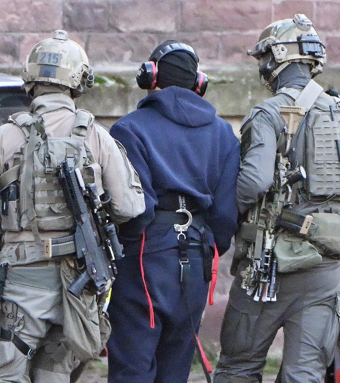 Baden-Württemberg, Karlsruhe: Eine Person wird von einem Hubschrauber zu einer Wagenkolonne geführt.