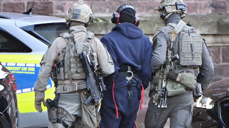 Baden-Württemberg, Karlsruhe: Eine Person wird von einem Hubschrauber zu einer Wagenkolonne geführt.