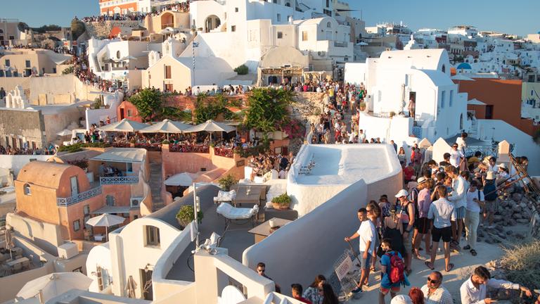 Wunderschönes Dorf Oia übervoll mit Touristen auf der Insel Santorini, Griechenland.