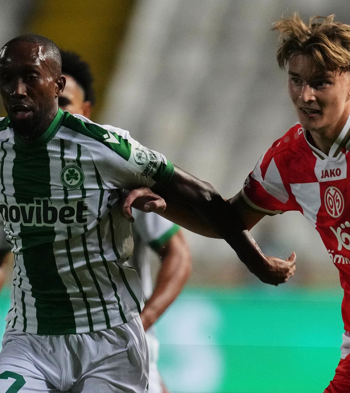 02.10.2025, Nikosia: Willy Semedo (l.) von Omonia wird im Conference-League-Spiel gegen Mainz 05 von Kacper Potulski unter Druck gesetzt.